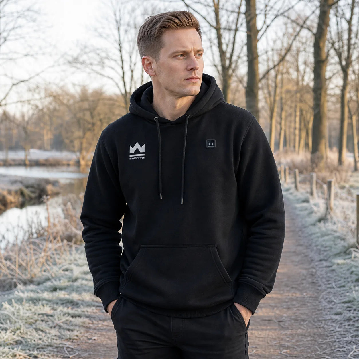 Man draagt zwarte KingsPower verwarmde hoodie tijdens winterwandeling