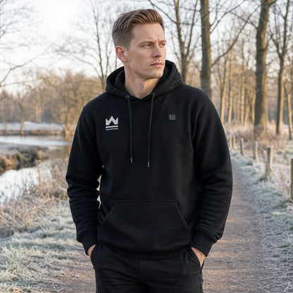 Man draagt zwarte KingsPower verwarmde hoodie tijdens winterwandeling